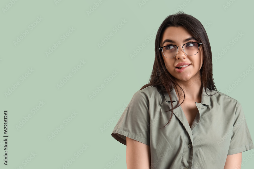 Cute young woman wearing glasses on color background