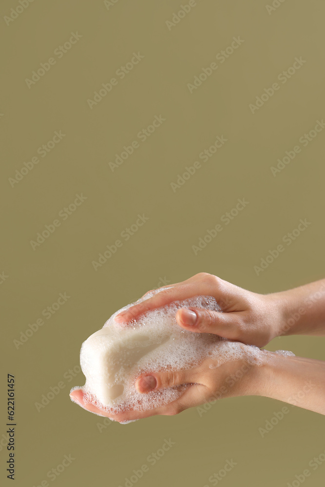 Hands with soap on color background