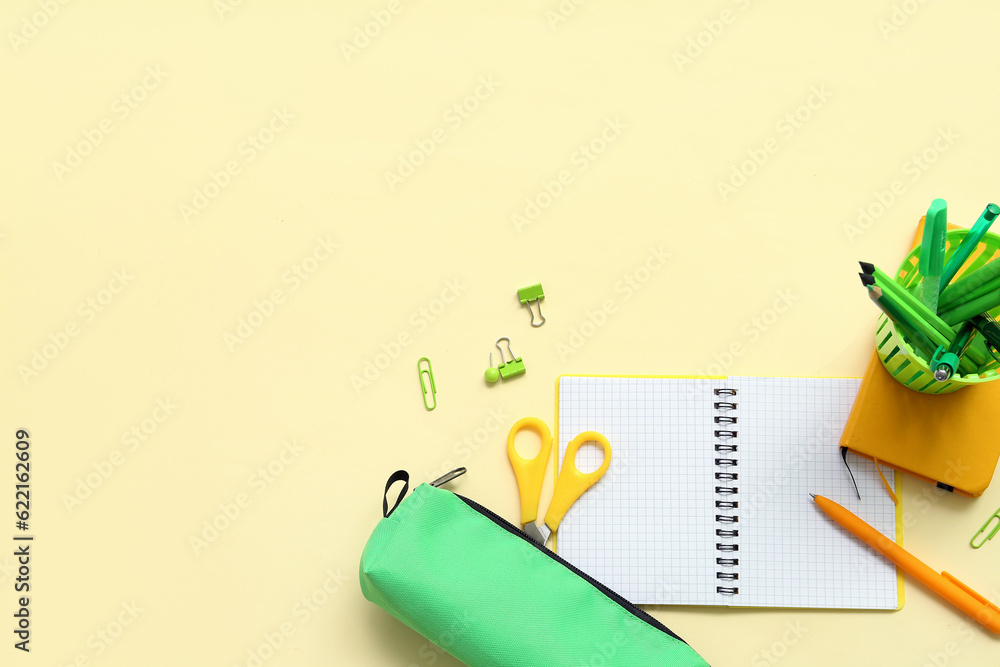 Notebook and school stationery on yellow background