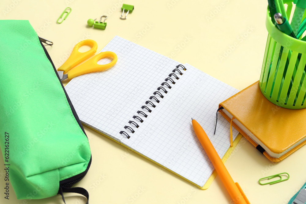 Notebook and school stationery on yellow background