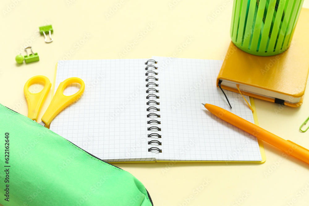 Notebook and school stationery on yellow background