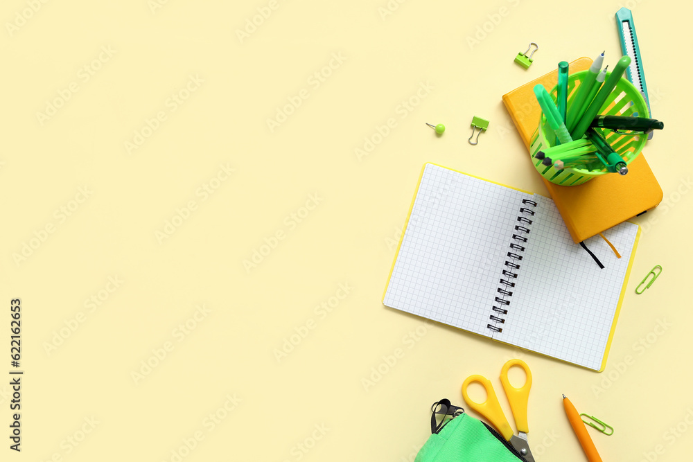 Notebook and school stationery on yellow background