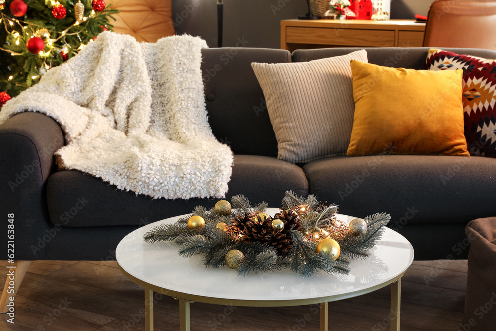 Comfortable sofa and coffee table with Christmas decorations in modern living room