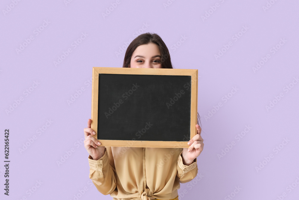 Female teacher with chalkboard on lilac background