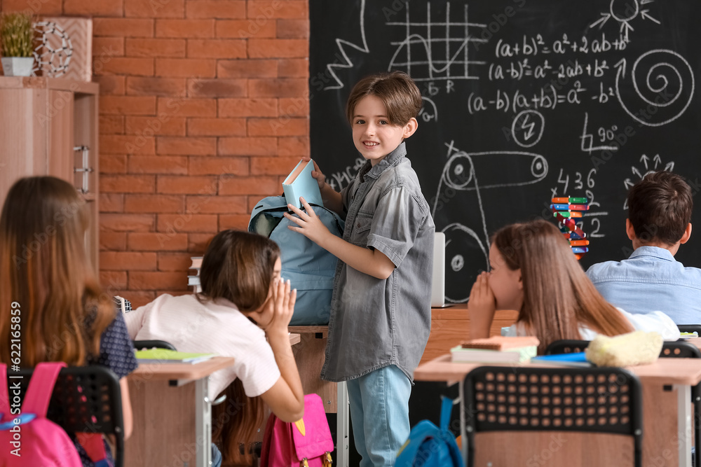 Little boy with backpack in classroom