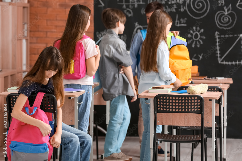 Little pupils with backpacks in classroom