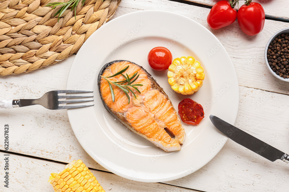 Plate with tasty grilled salmon steak on light wooden background