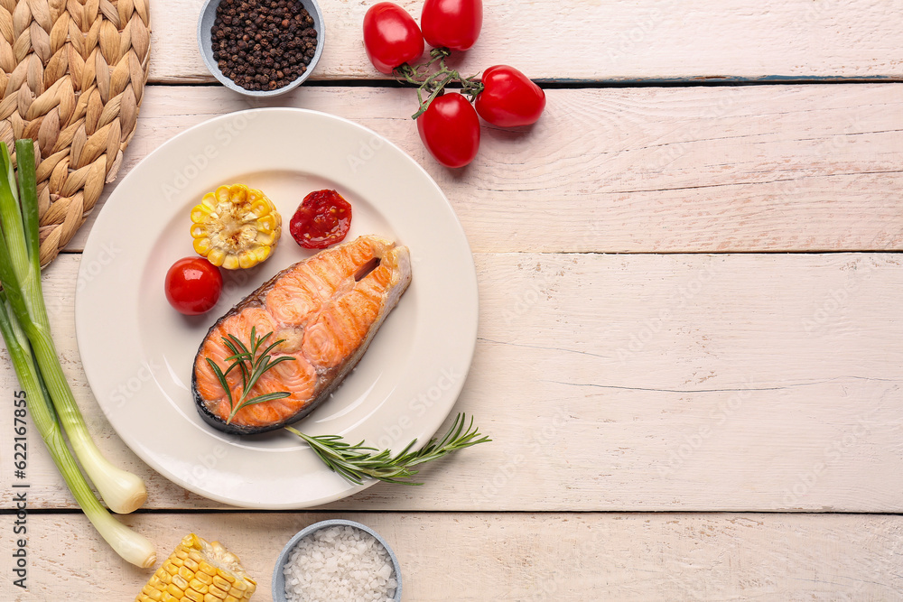 Plate with tasty grilled salmon steak on light wooden background