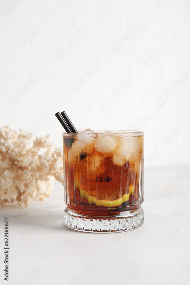 Glass of cold Cuba Libre cocktail and coral on white background