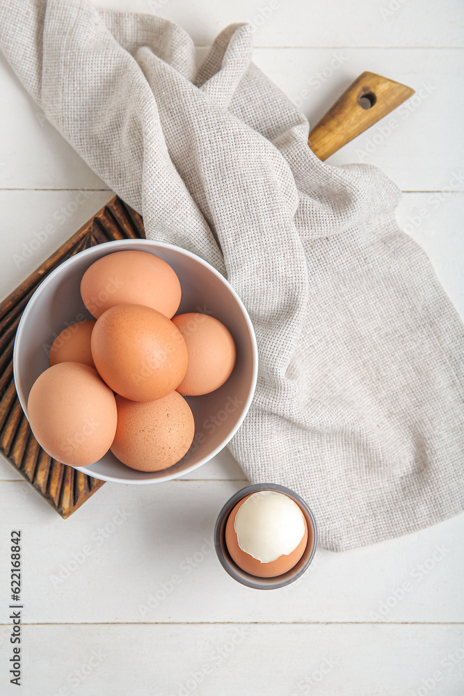 Holder with boiled chicken egg on white wooden background