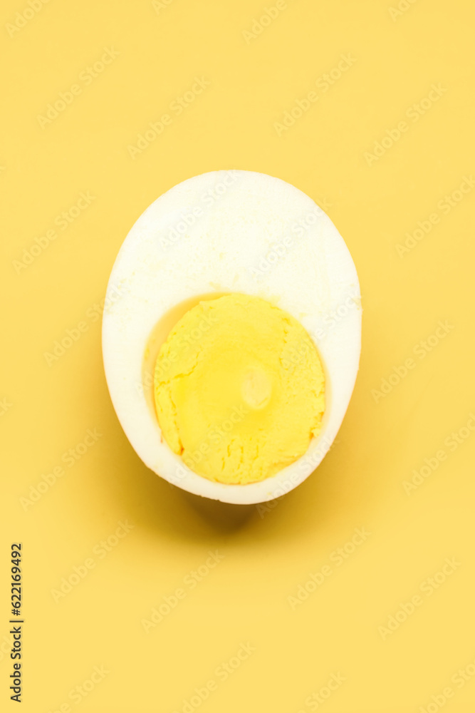 Half of tasty boiled egg on yellow background