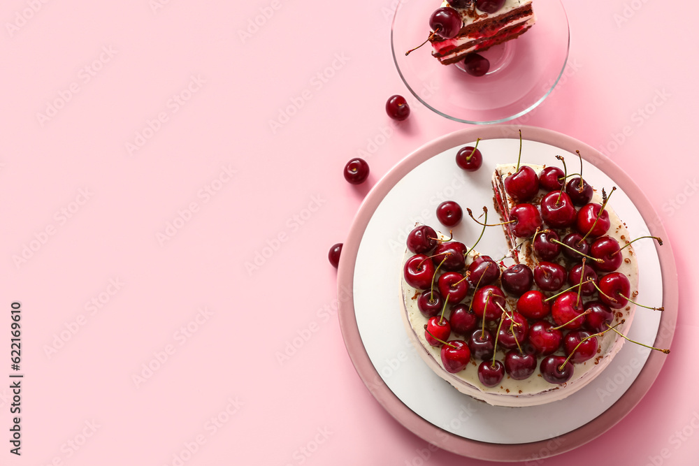 Plates with tasty cherry cake on pink background