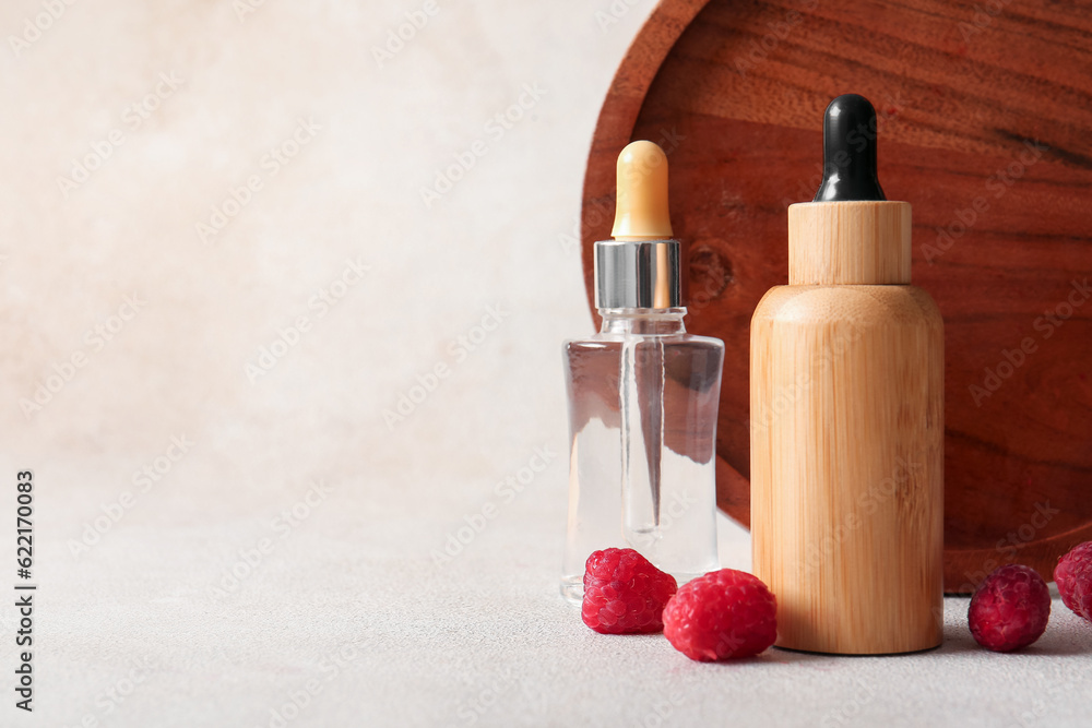 Bottles of cosmetic raspberry oil on white background