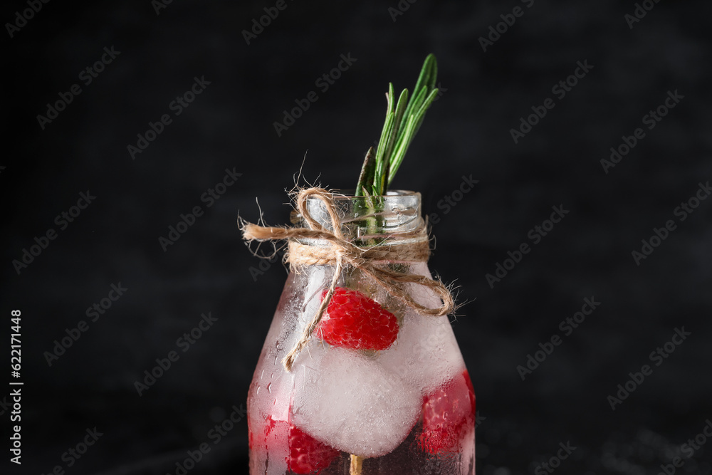 Bottle of fresh raspberry lemonade with rosemary on black background