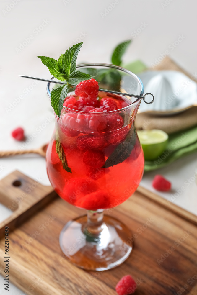 Glass of fresh raspberry lemonade with mint on white background