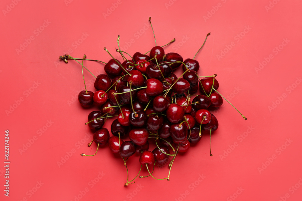 Heap of red sweet cherries on color background