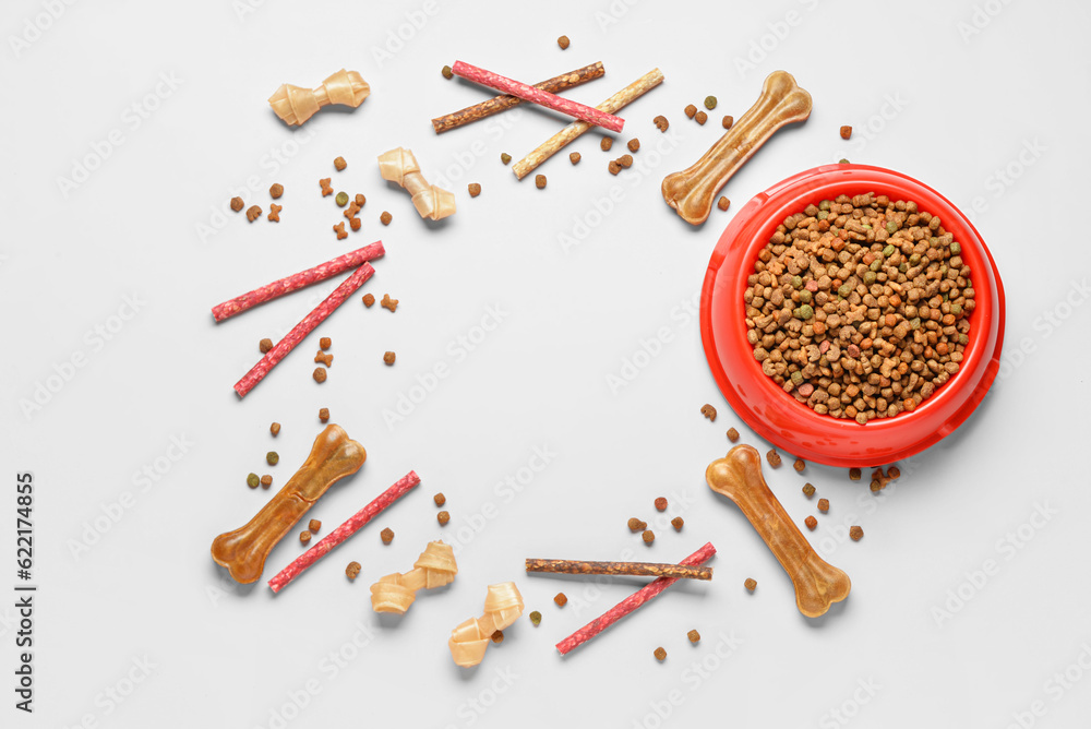 Frame made of different dog food on light background