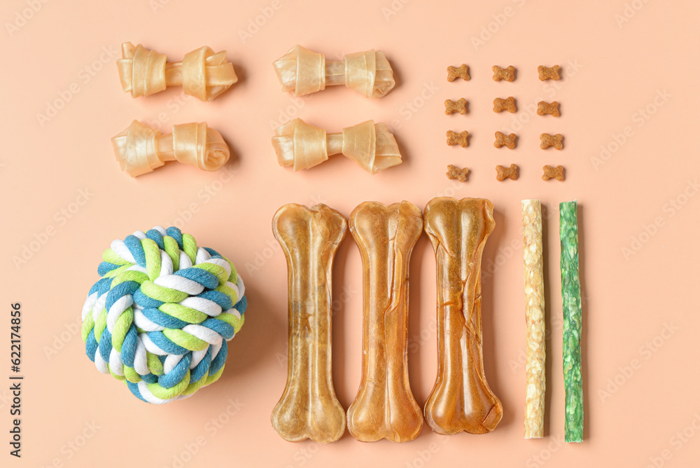 Composition with different dog treats and toy ball on color background