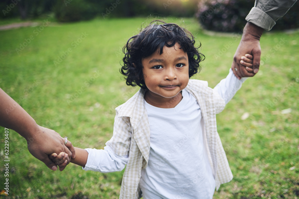 Nature, cute and boy child holding hands with his parents while walking in an outdoor park. Sweet, y