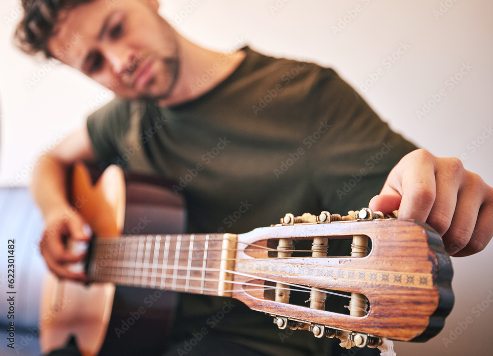 Closeup, man and tuning guitar for music, talent and creative skill of sound production in home stud