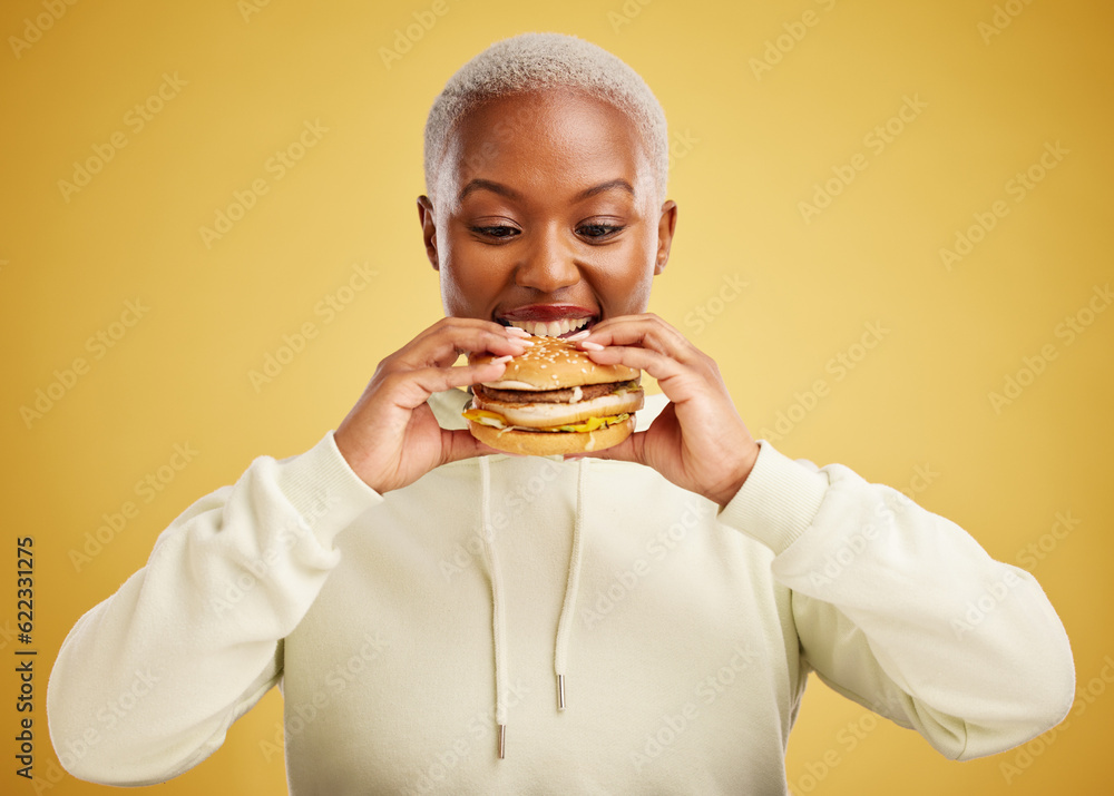 Burger, eating and woman or happy student on a studio, yellow background for restaurant promotion or