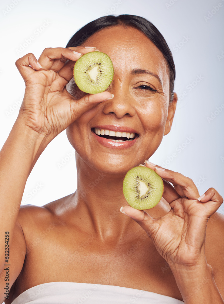 Face, skincare and senior woman with kiwi in studio isolated on a white background. Food, natural fr