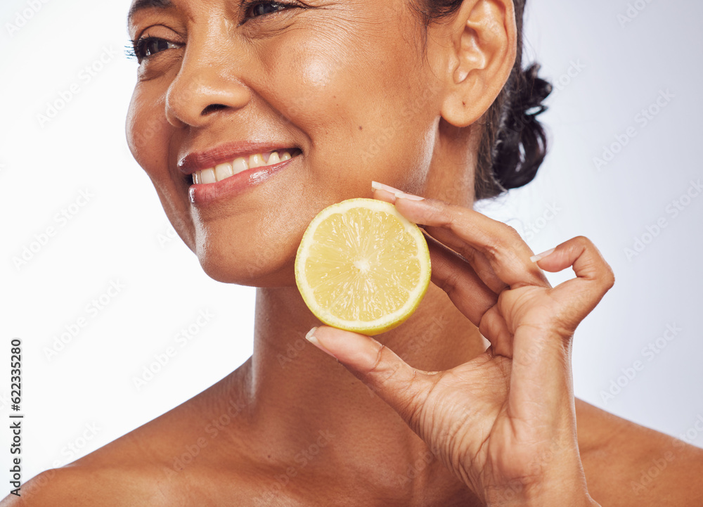 Thinking, orange and senior woman with skincare, cosmetics and vitamin c against a white studio back