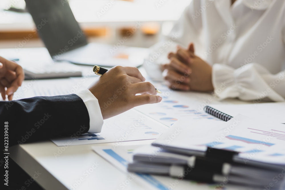 Financial advisor discussing business management planning with businesswoman in office.