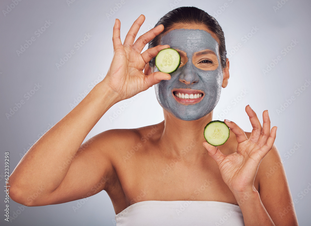 Portrait, cucumber and mask with a model woman in studio on a gray background for an antiaging facia