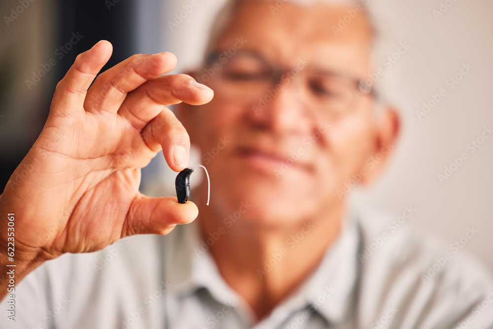 Hand holding hearing aid, senior man and tech for ears, health and wellness for retirement in nursin