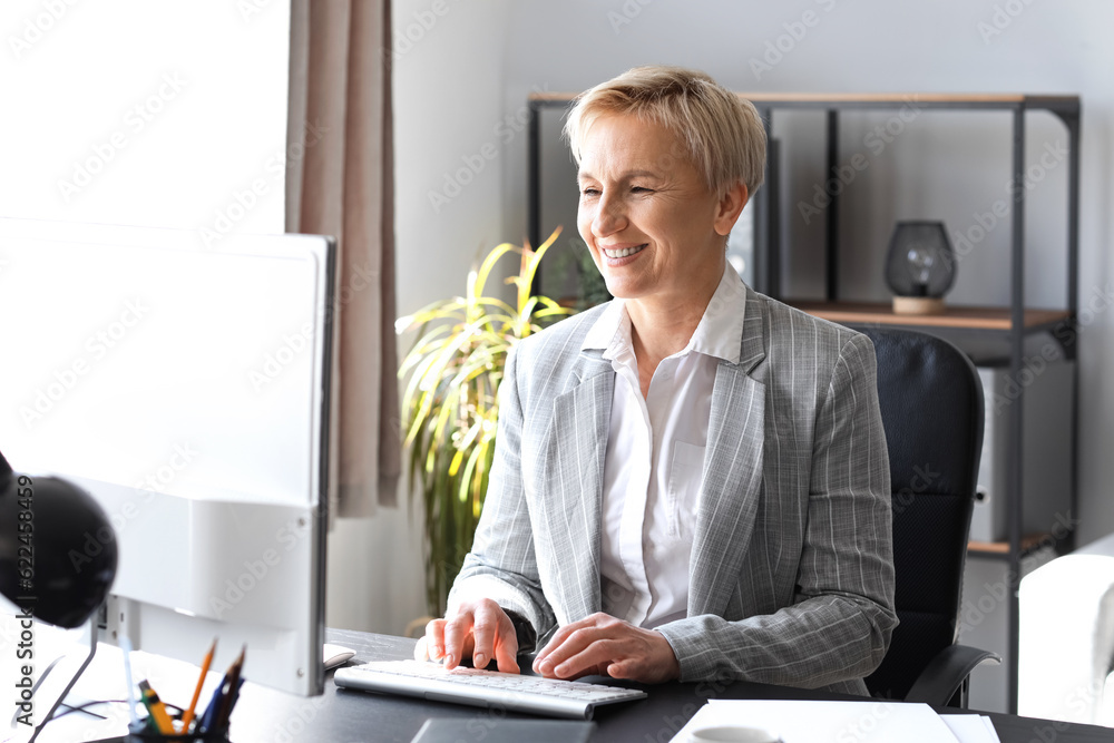 Mature businesswoman working on PC in office