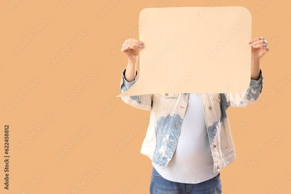 Young pregnant woman with blank speech bubble on beige background