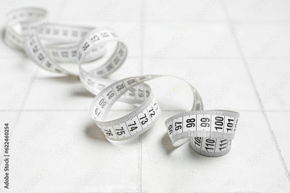 New measuring tape on white background, closeup