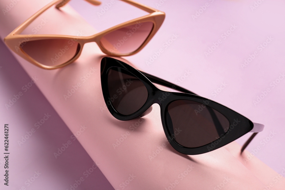 Modern eyeglasses on pink background, closeup