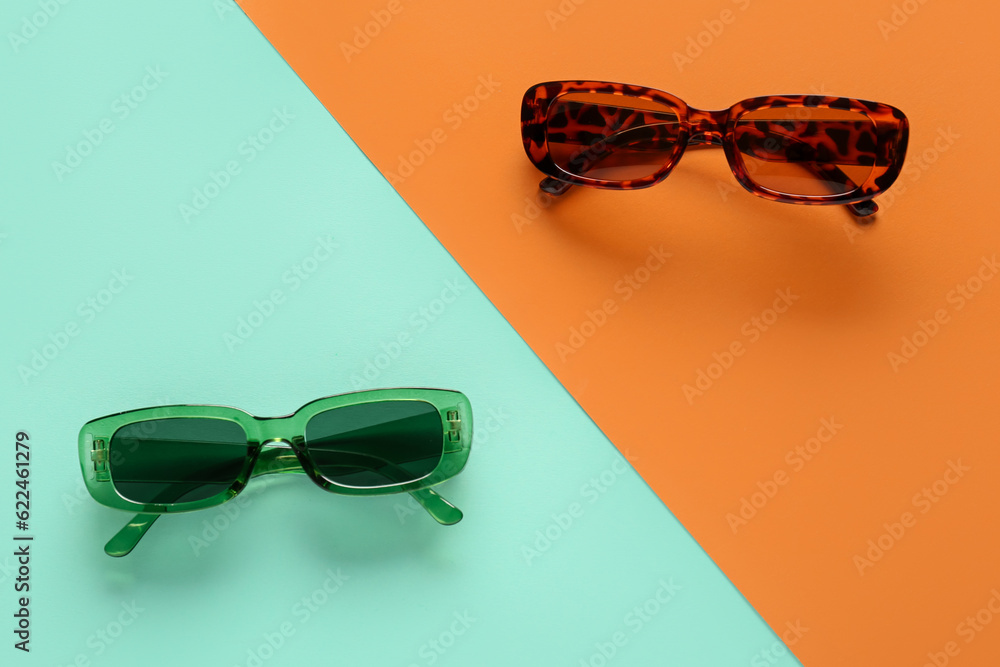 Modern eyeglasses on color background