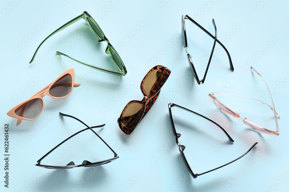 Different stylish eyeglasses on blue background