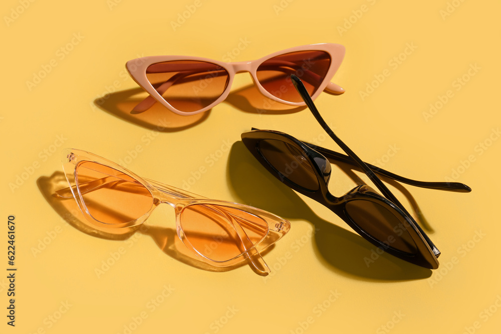 Stylish eyeglasses on yellow background