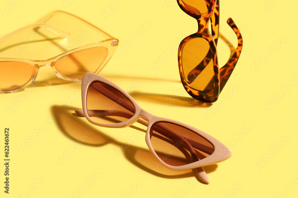 Stylish eyeglasses on yellow background