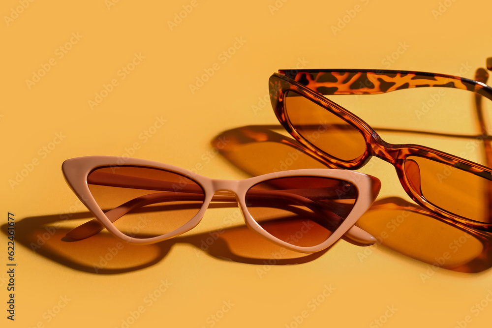 Stylish eyeglasses on yellow background, closeup