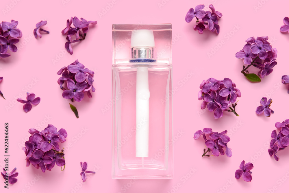 Beautiful lilac flowers and bottle of perfume on pink background