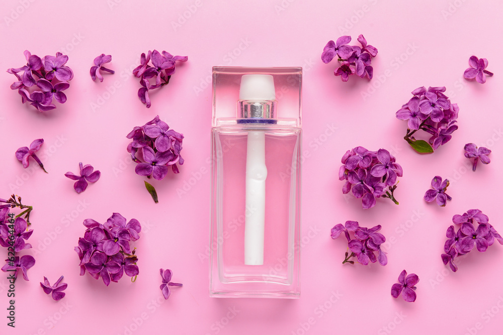 Beautiful lilac flowers and bottle of perfume on pink background