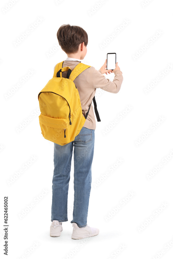 Little boy with schoolbag and mobile phone on white background