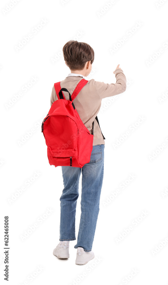 Little boy with schoolbag pointing at something on white background