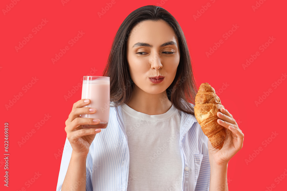 Young woman with tasty yoghurt and croissant on red background, closeup