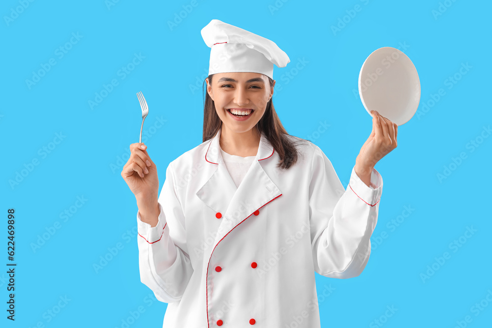 Female chef with fork and plate on blue background