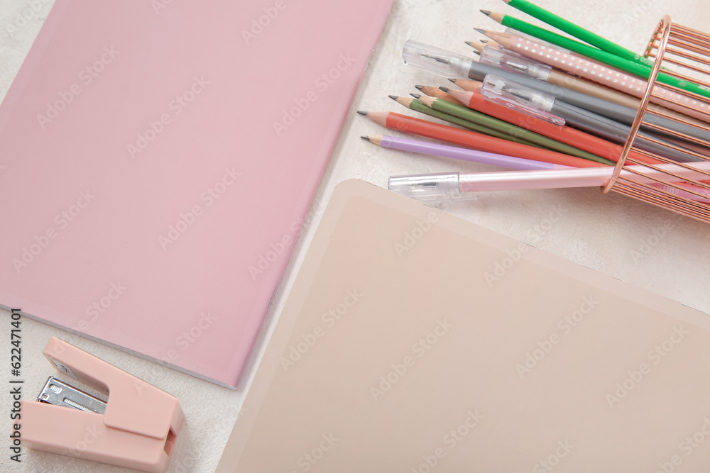 Notebooks with pens and pencils holder on white background