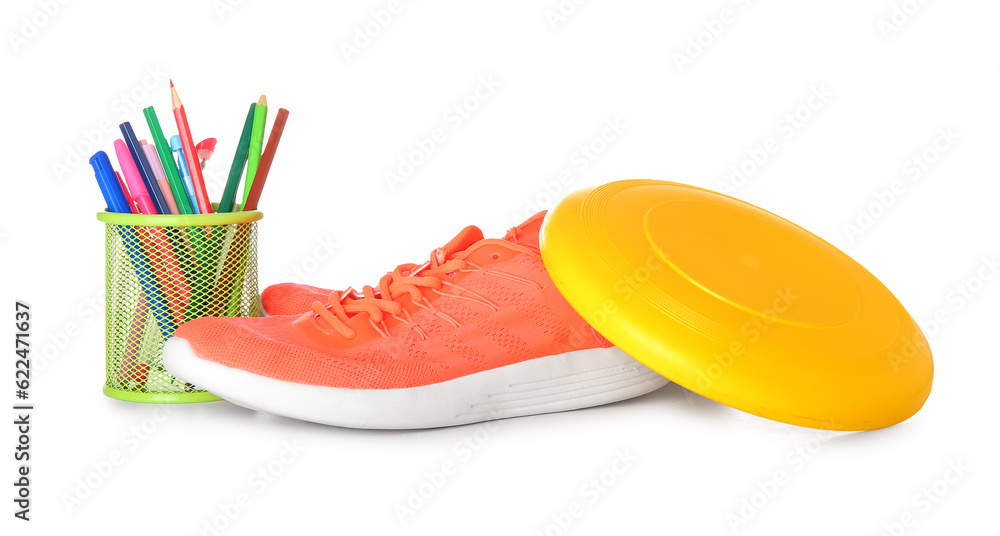 Sneakers with frisbee disk and stationery holder isolated on white background