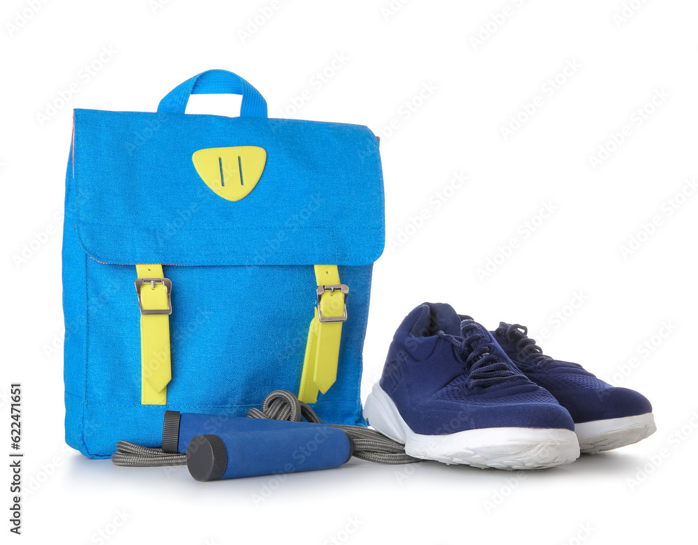 Backpack with sneakers and skipping rope isolated on white background