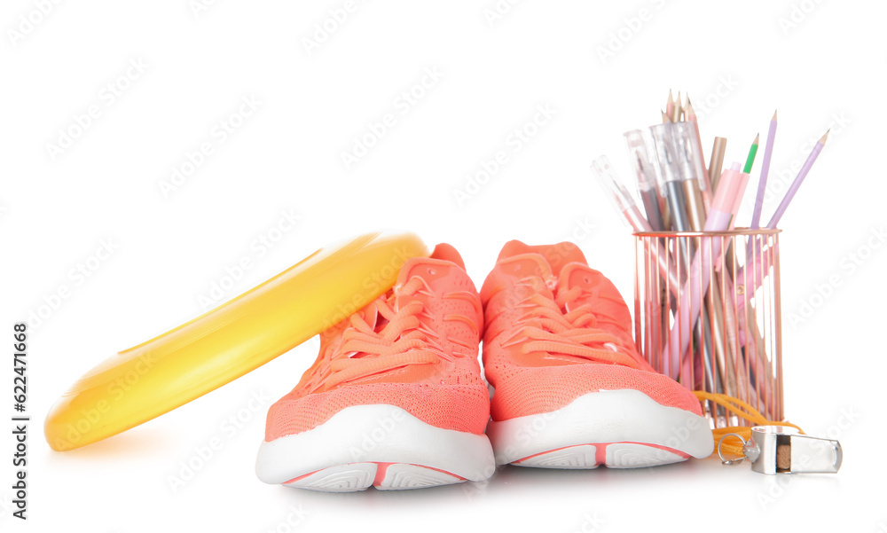 Sneakers with frisbee disk, whistle and stationery holder isolated on white background