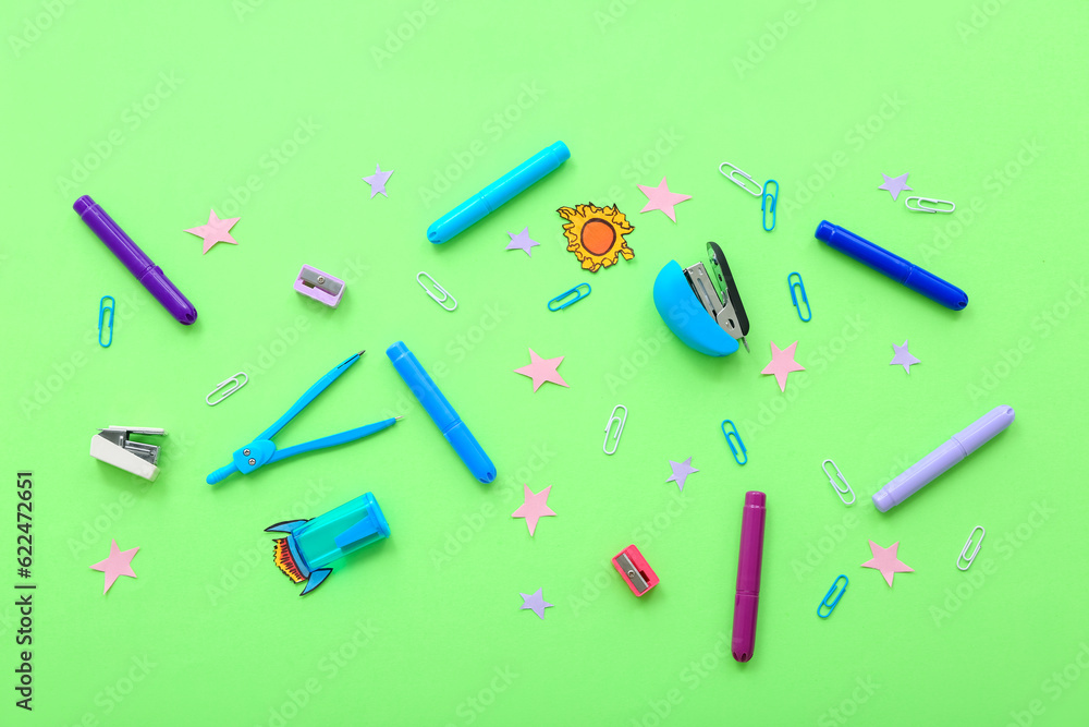 Creative composition with paper rocket, stars and different stationery on green background